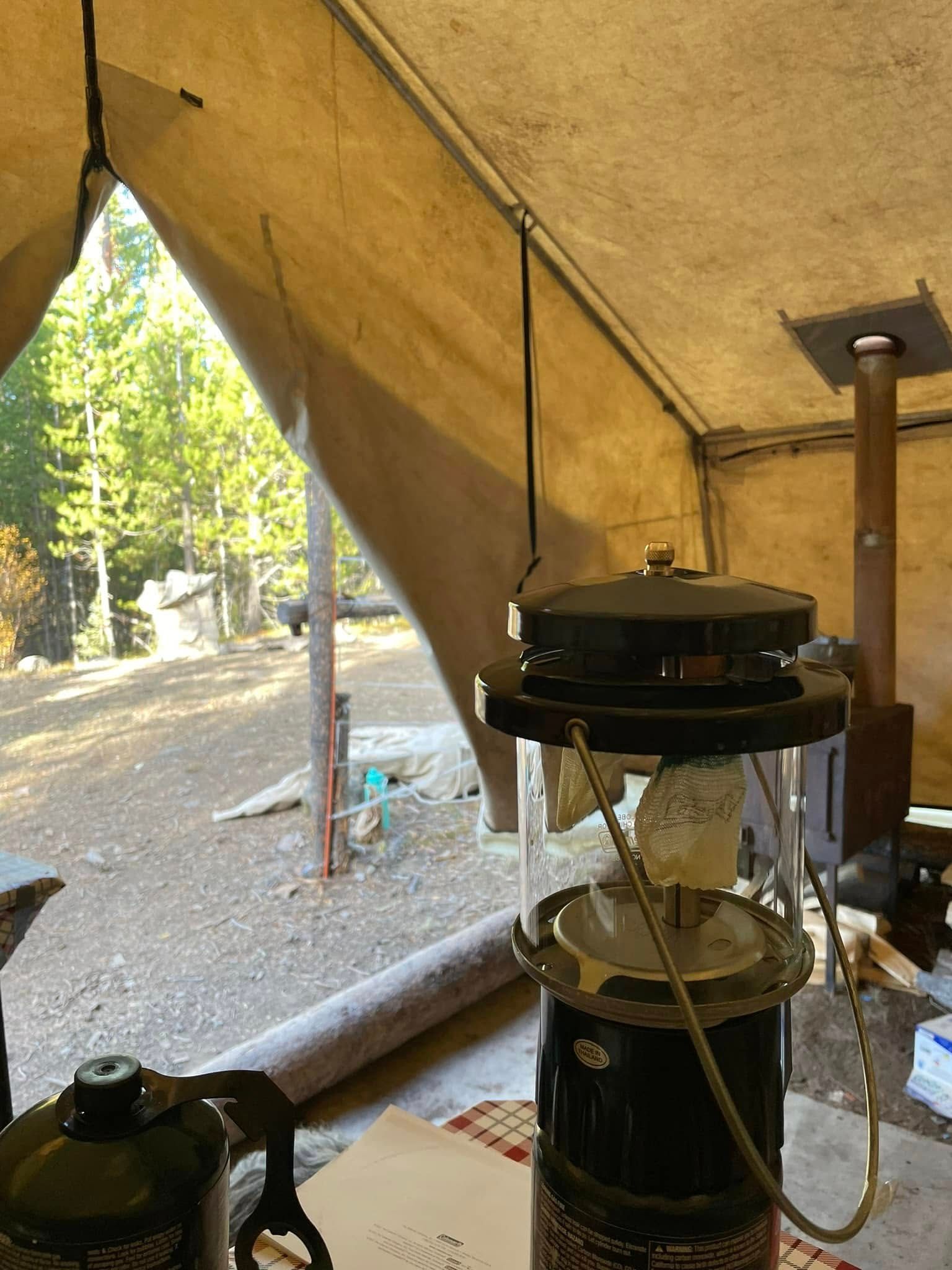 A lantern is sitting on a table in a tent.