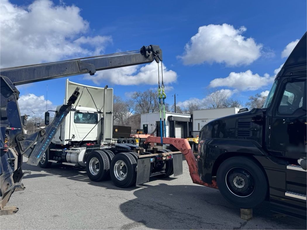A semi truck is being towed by a tow truck.