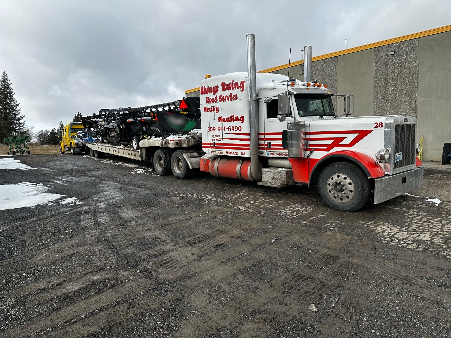 A red and white semi truck is parked in a parking lot.