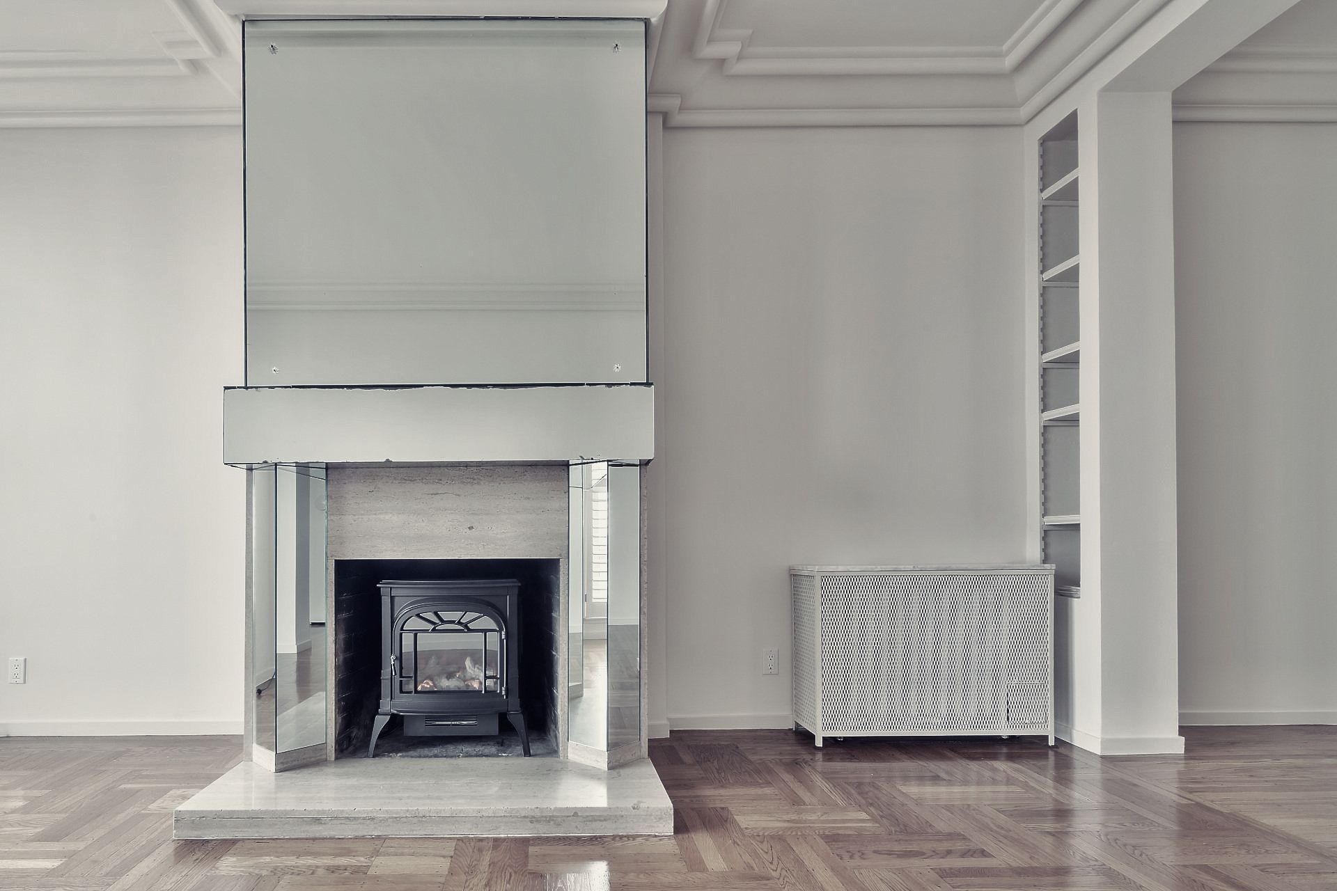 Empty clean house facing toward the fireplace with a bookshelf to the right