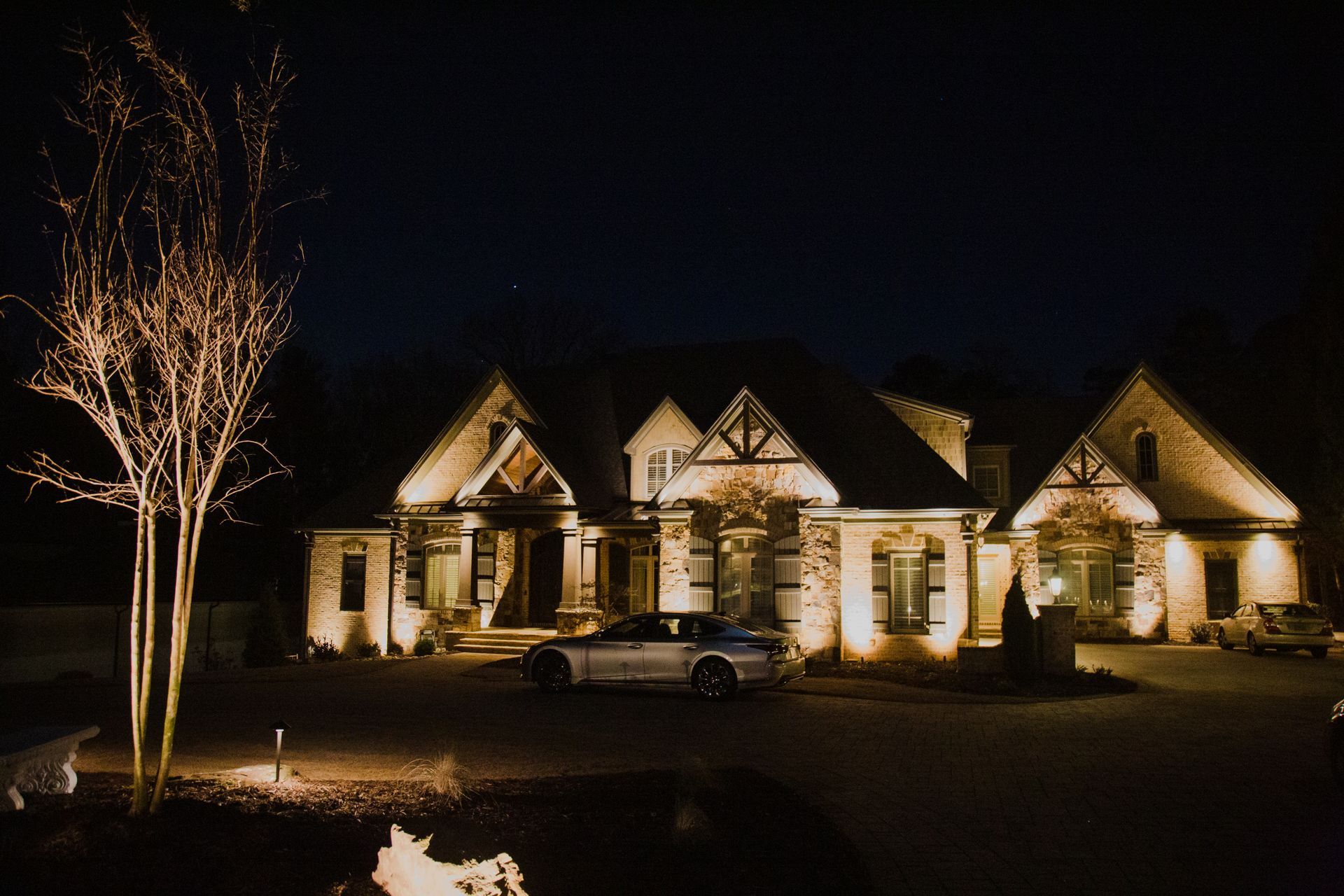 Contemporary home and driveway showcased by exterior lighting