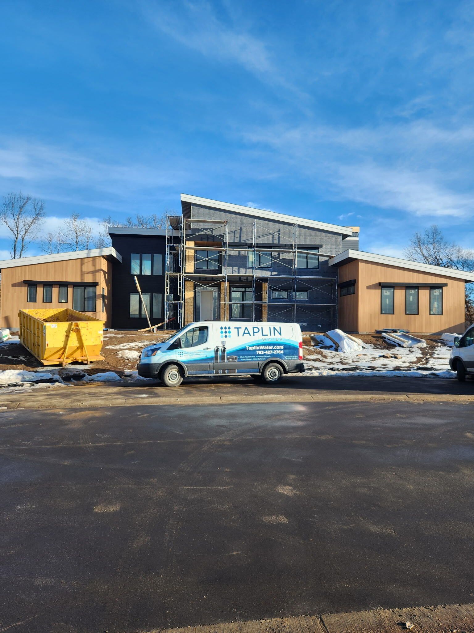 A van is parked in front of a building under construction.