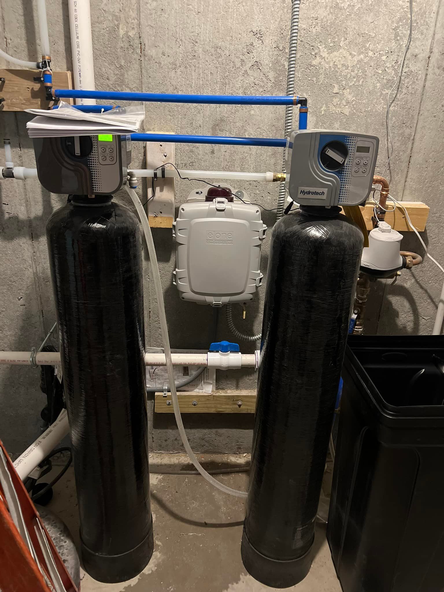 Two black water filters are sitting next to each other in a room.
