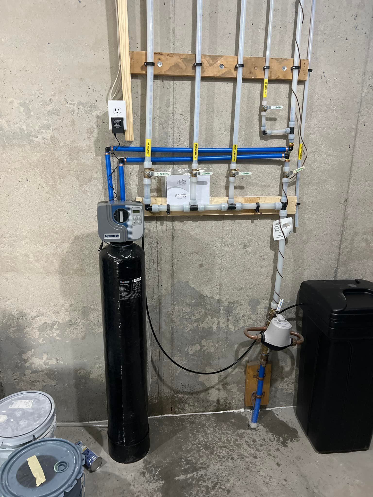 A water treatment system is being installed in a basement.
