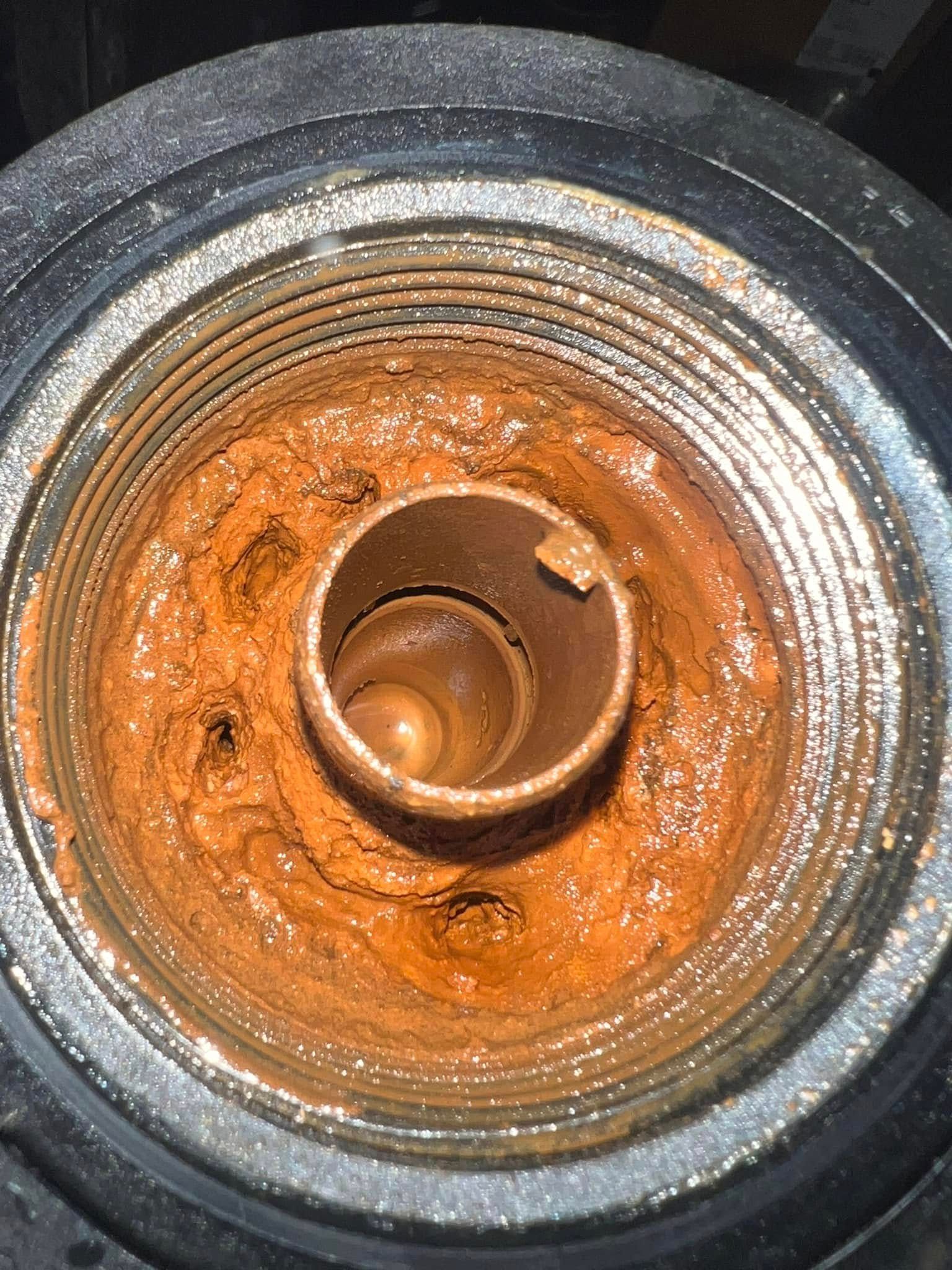 A close up of a rusty metal object with a hole in the middle.