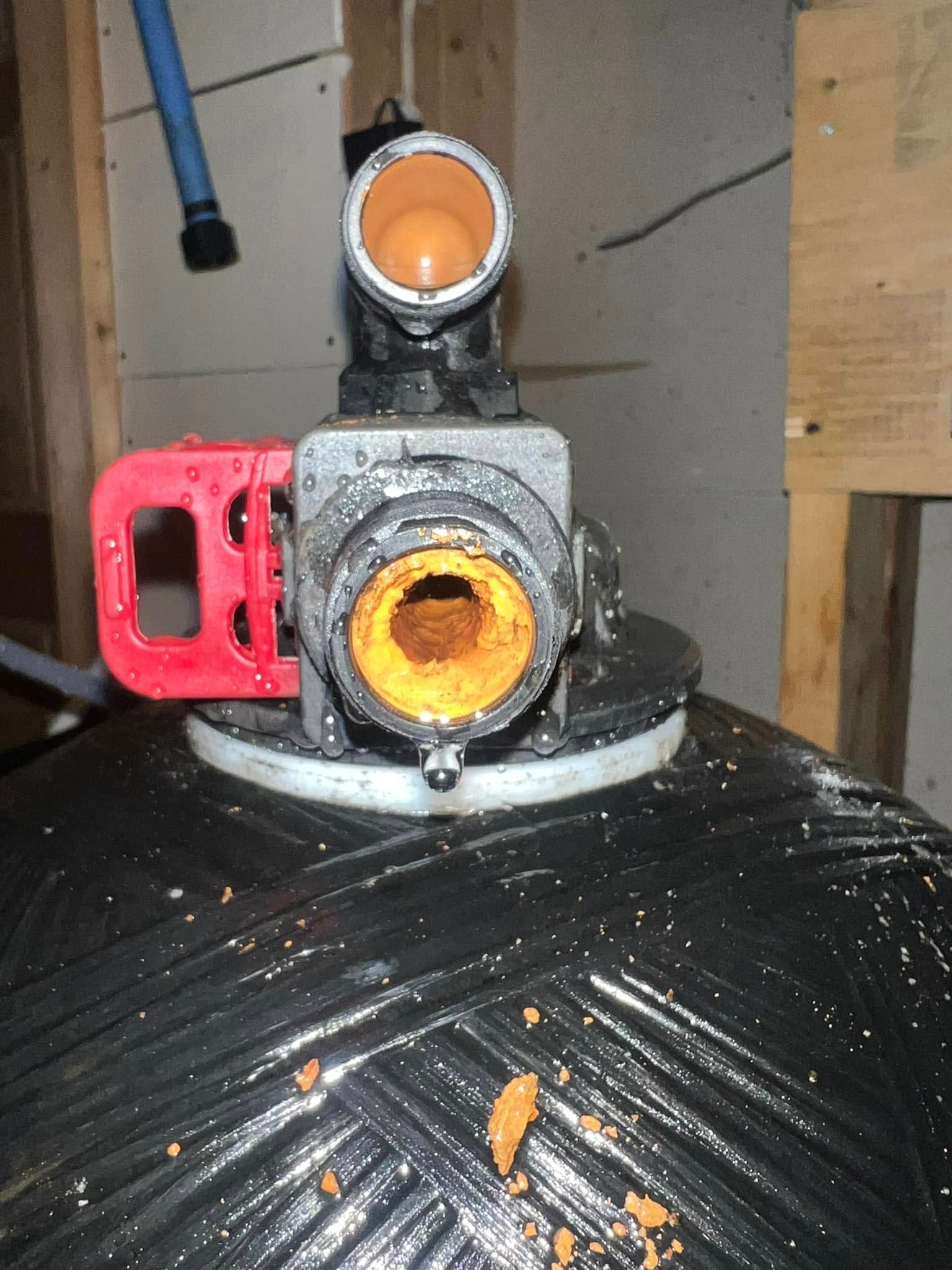 A close up of a water heater with a red handle