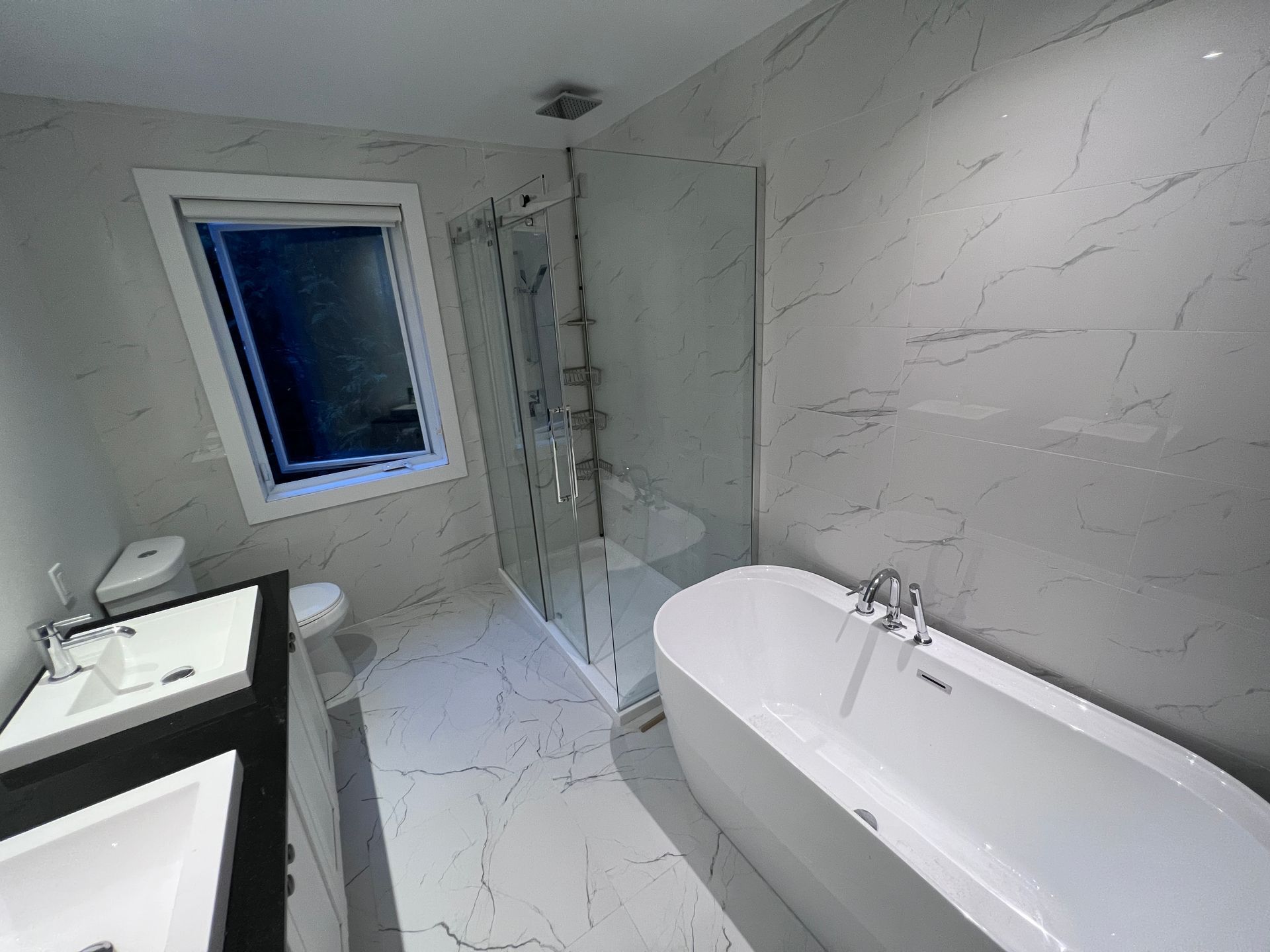 Une salle de bain avec baignoire, lavabo, WC et douche.