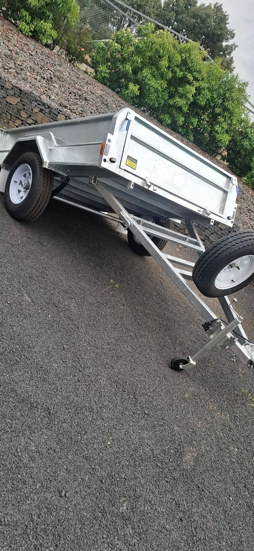 A silver trailer on a gravel surface. The trailer is angled — Towform Trailers in Brocklehurst, NSW