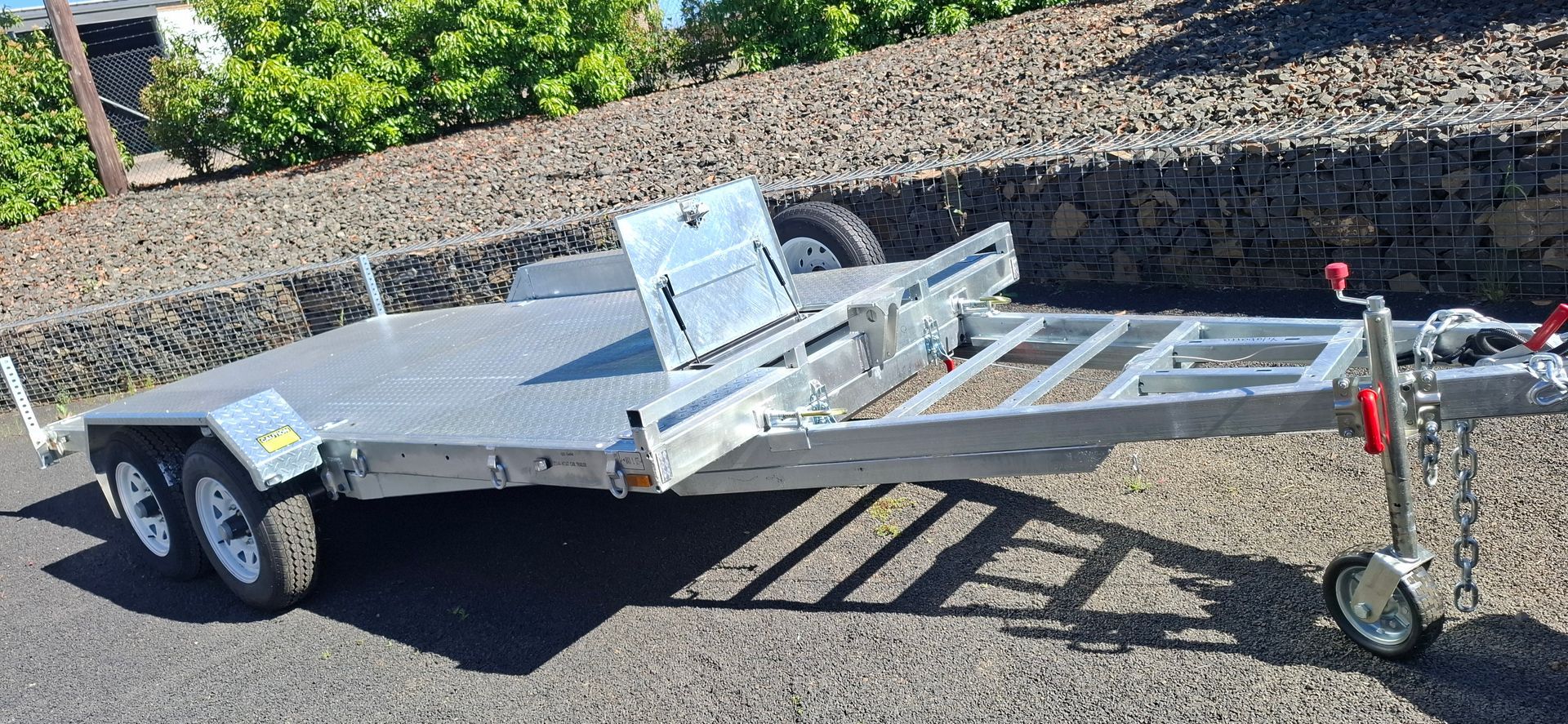 A silver utility trailer with a checkered platform, parked outdoors on asphalt — Towform Trailers in Brocklehurst, NSW