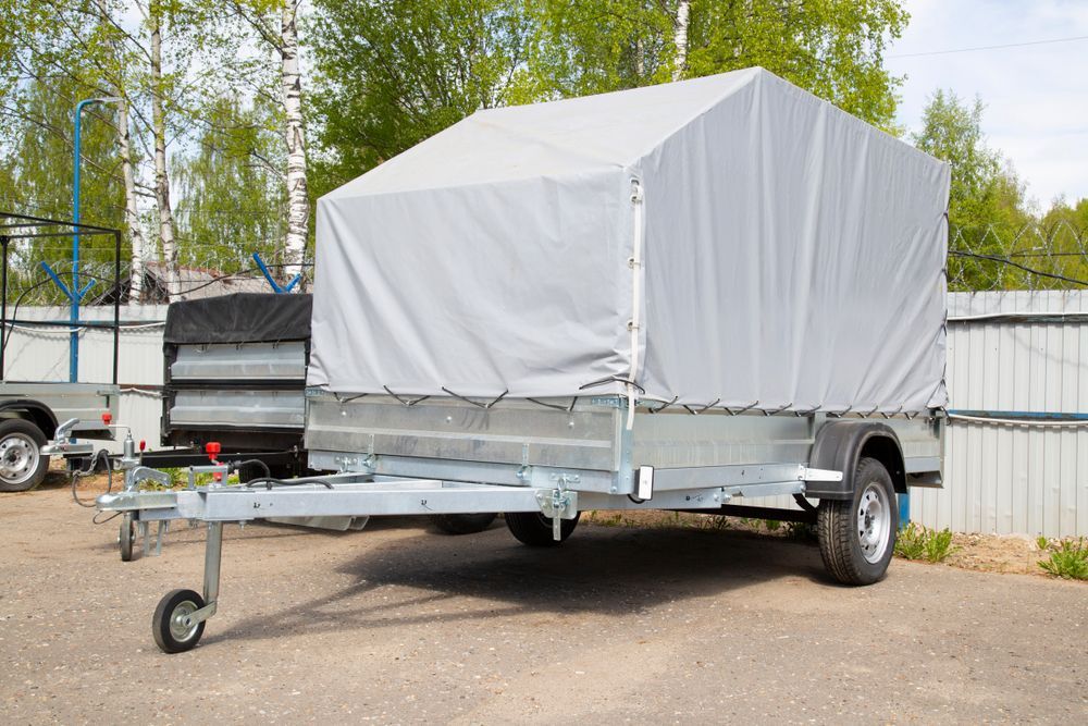 Silver Trailer With A Gray Tarp Cover, Parked Outside — Towform Trailers in Brocklehurst, NSW