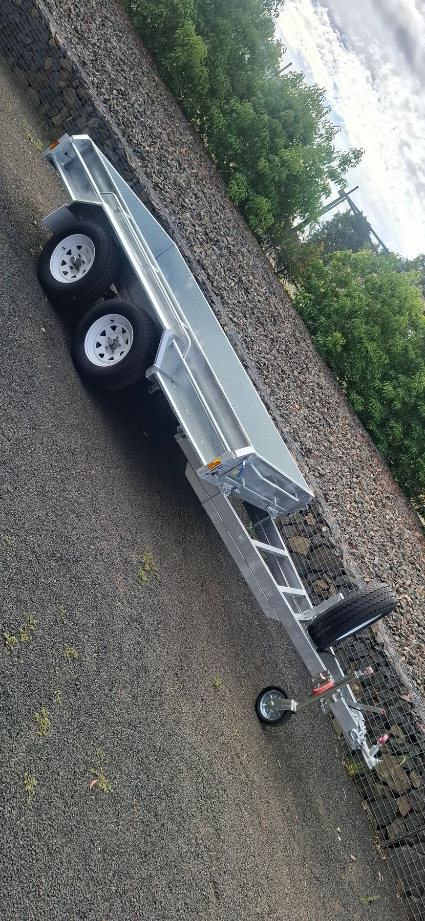 A silver utility trailer parked on gravel, trees in the background — Towform Trailers in Brocklehurst, NSW