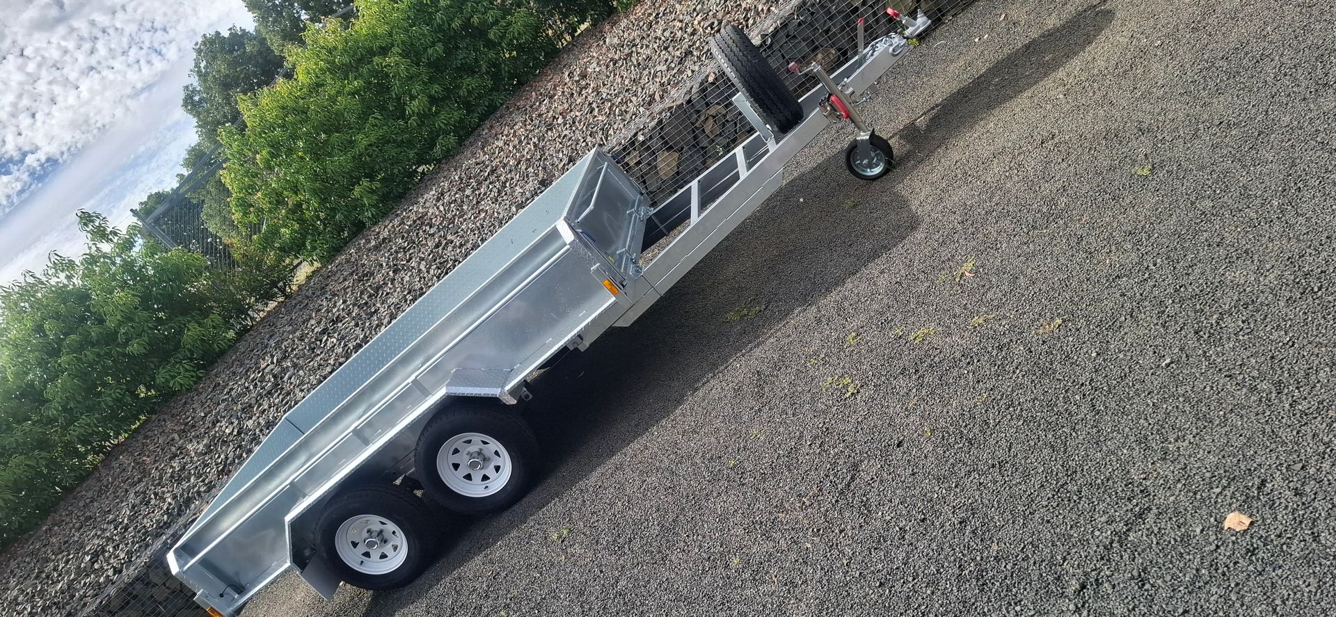 A silver trailer on a paved surface, next to a green hedge and some snow — Towform Trailers in Brocklehurst, NSW