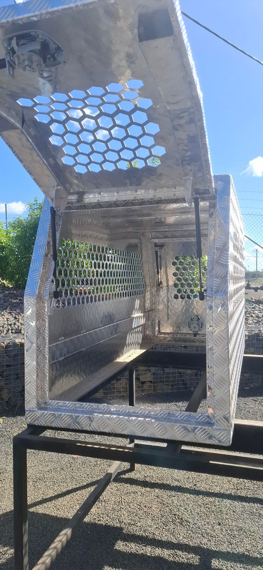 Open metal toolbox with honeycomb-shaped ventilation, resting on a stand outdoors — Towform Trailers in Brocklehurst, NSW