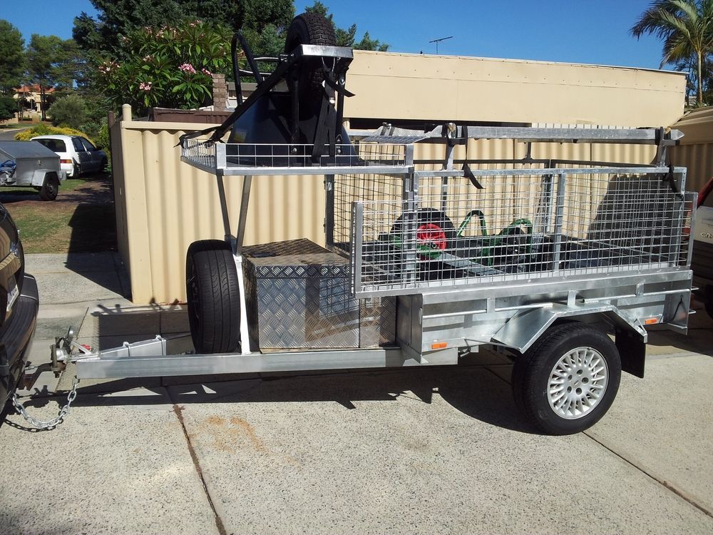 Silver Utility Trailer With Mesh Sides and a Cargo Basket, Parked on a Driveway — Towform Trailers in Brocklehurst, NSW