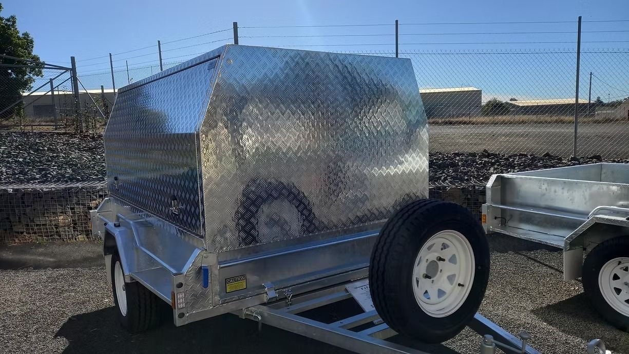 Silver Trailer With Diamond Plate Canopy, Spare Tire Attached, Parked Outdoors — Towform Trailers in Brocklehurst, NSW