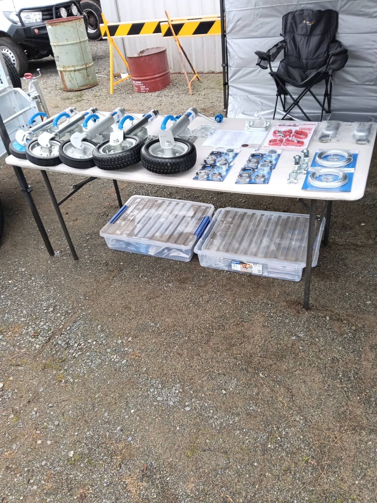 Table Display Various Trailer Parts, Wheels, and Hardware Arranged — Towform Trailers in Brocklehurst, NSW