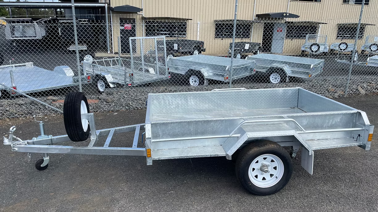 Galvanized Utility Trailer With Spare Tire In A Yard With Other Trailers — Towform Trailers in Brocklehurst, NSW