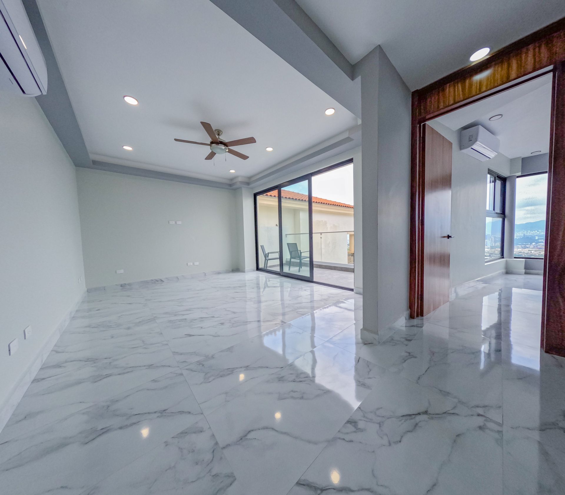 Estancia con ventanales de piso a techo y detalles de lambrin
