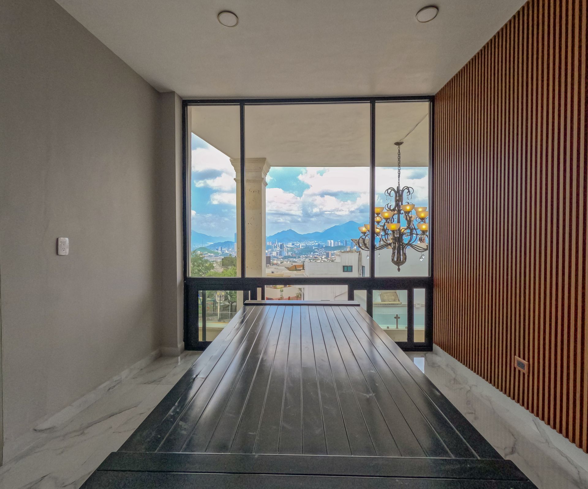 Comedor con ventanal de piso a techo y lambien en pared