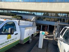 A row of white garage doors on the side of a house