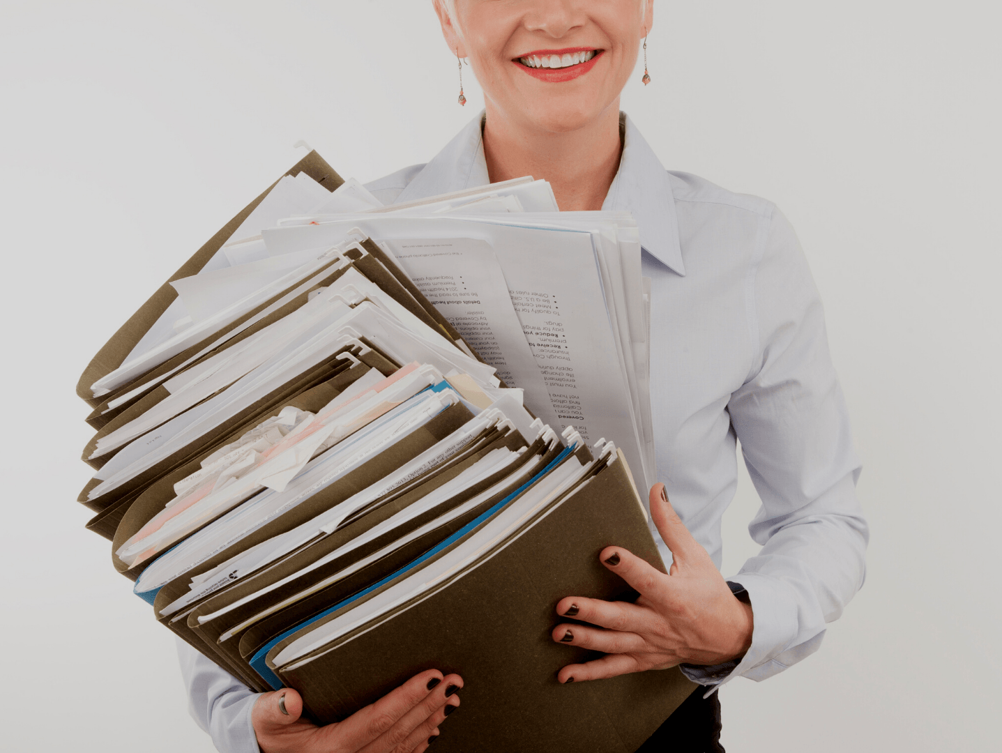 A woman is holding a stack of folders in her hands