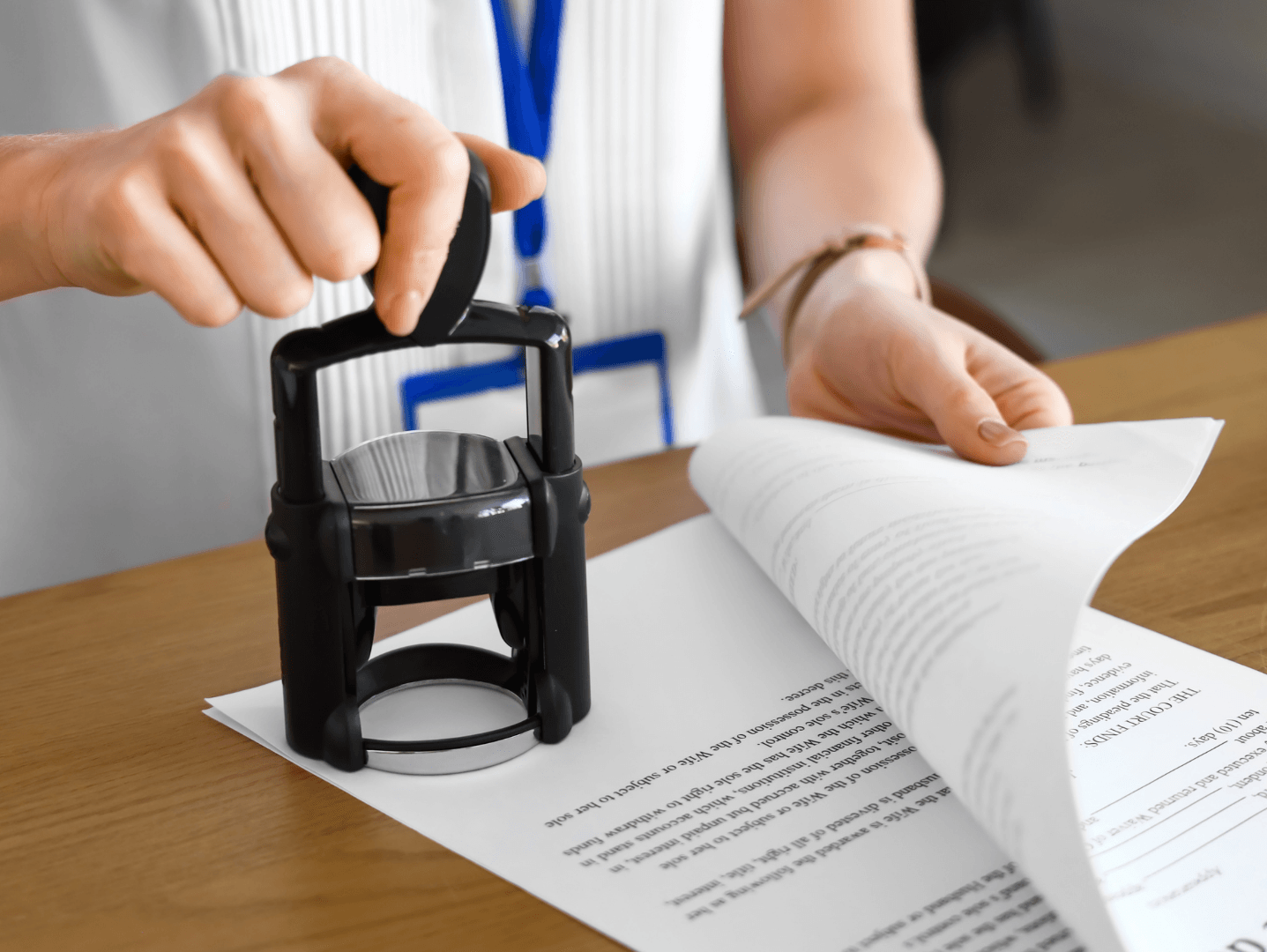 A person is putting a stamp on a piece of paper.