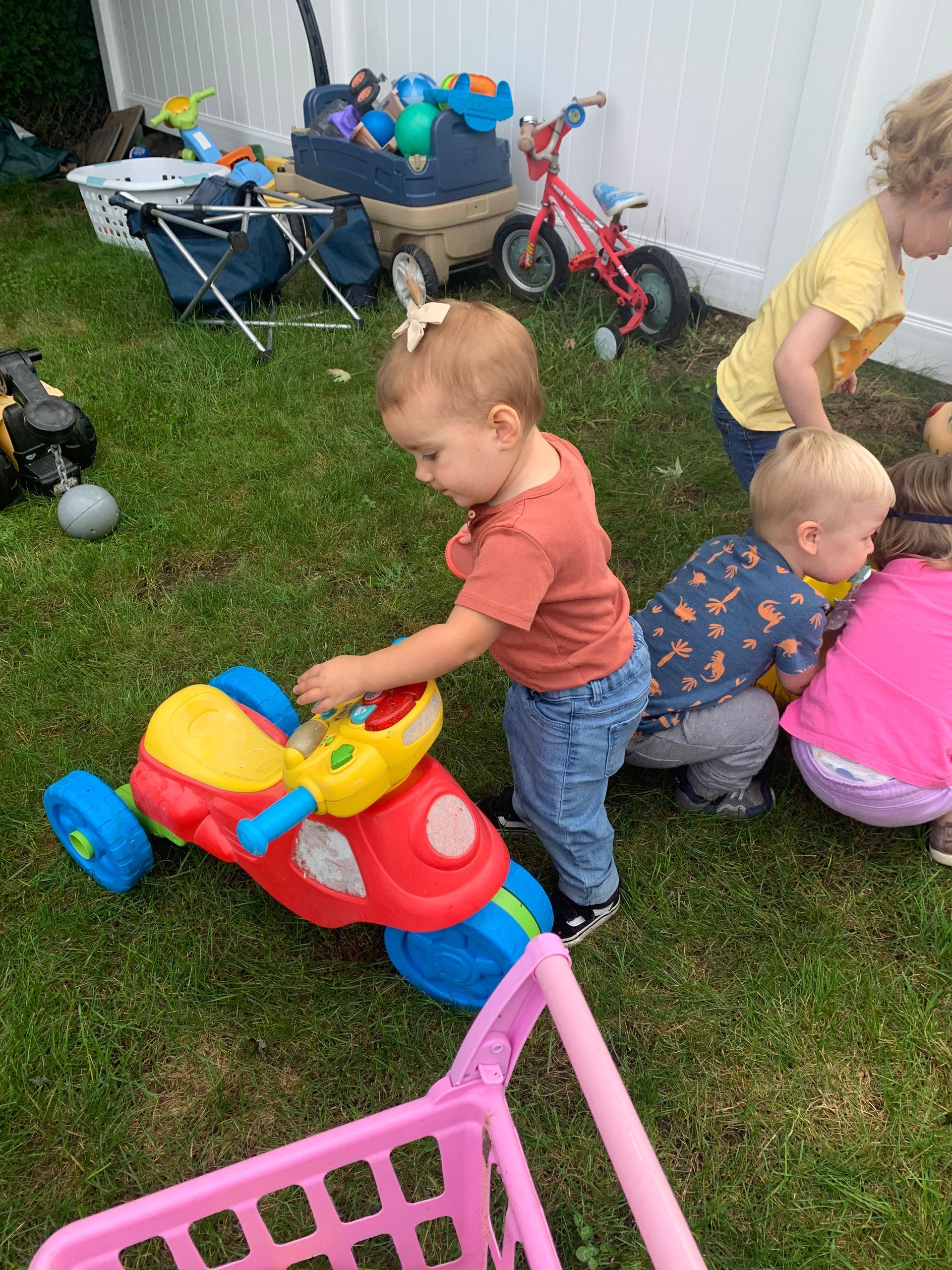 A group of children are playing with toys in the grass.