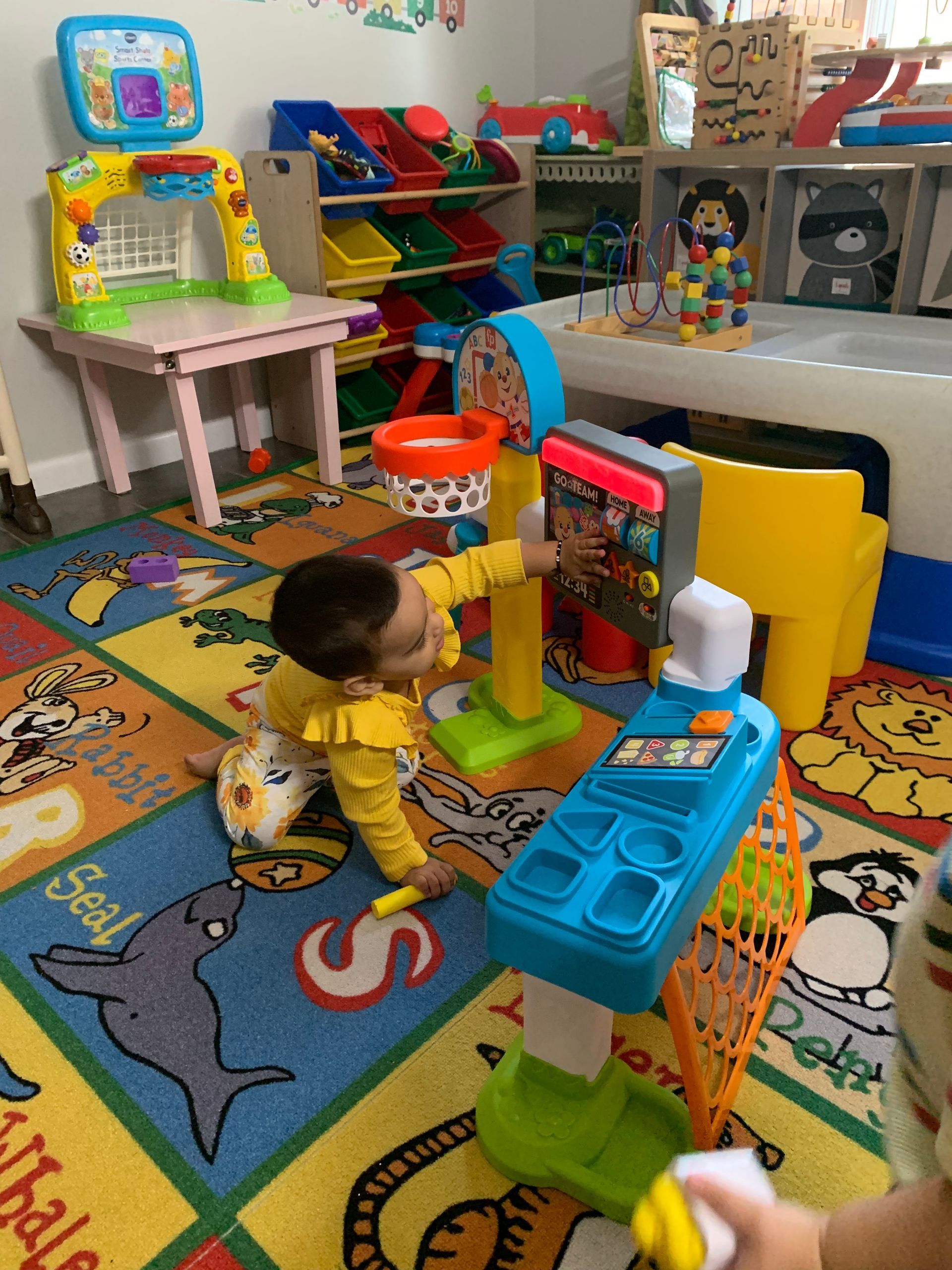 A baby is playing with toys in a play room.