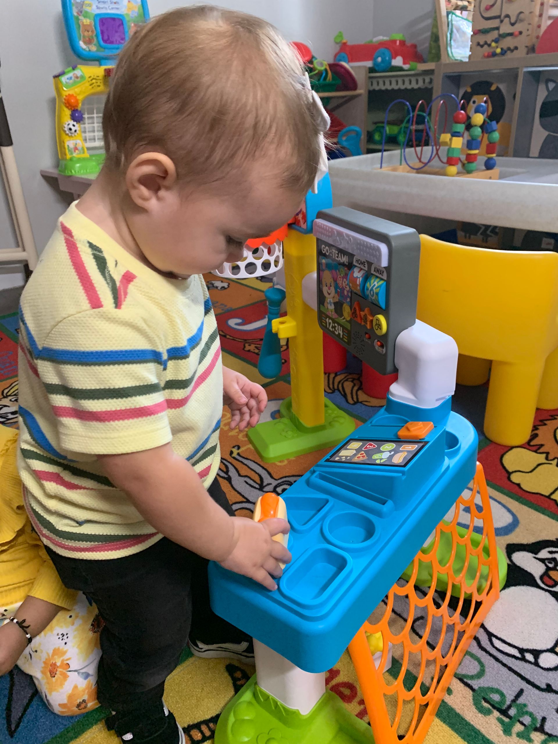 A baby is playing with a toy in a room.