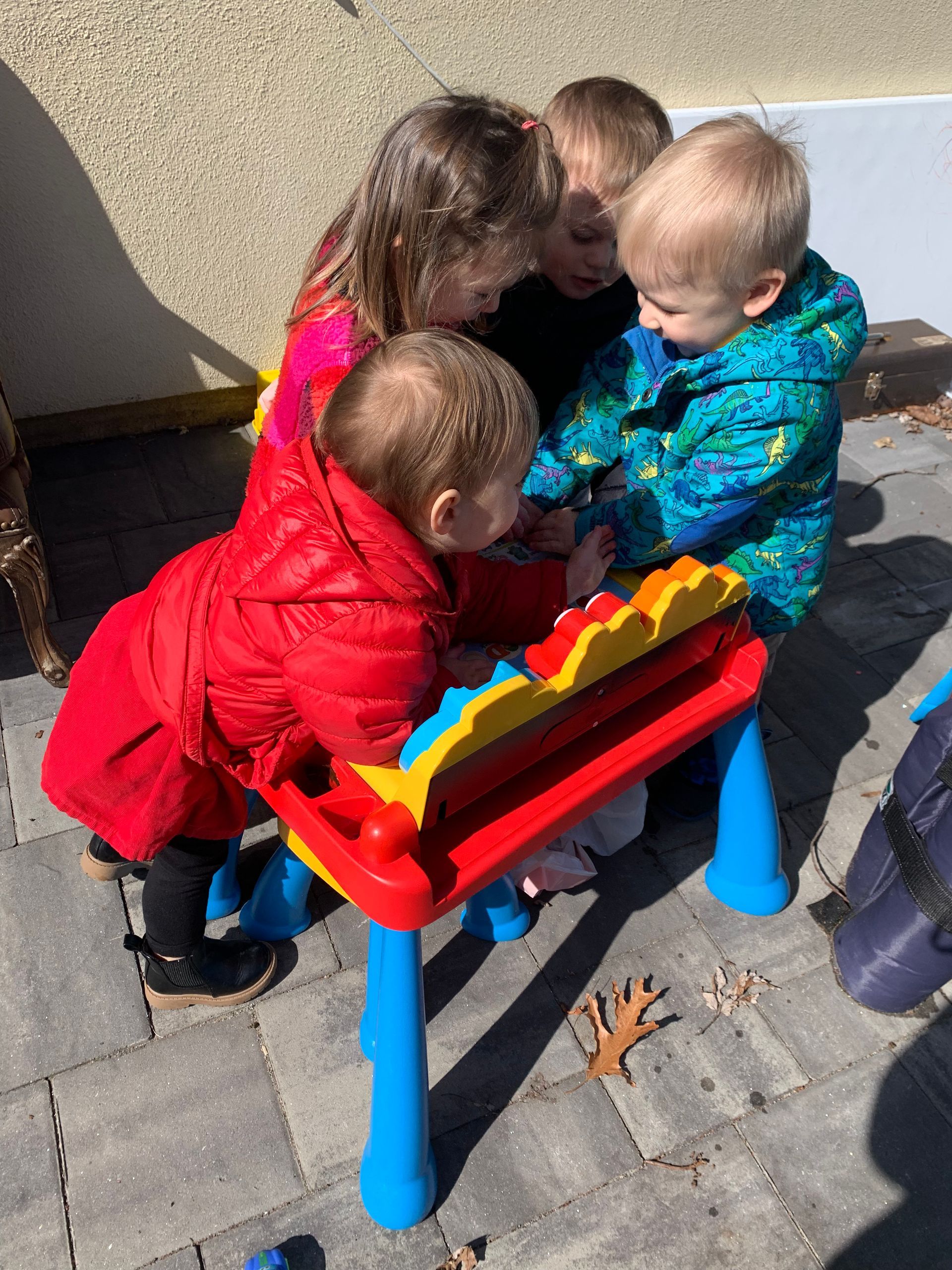 A group of children are playing with a toy table.