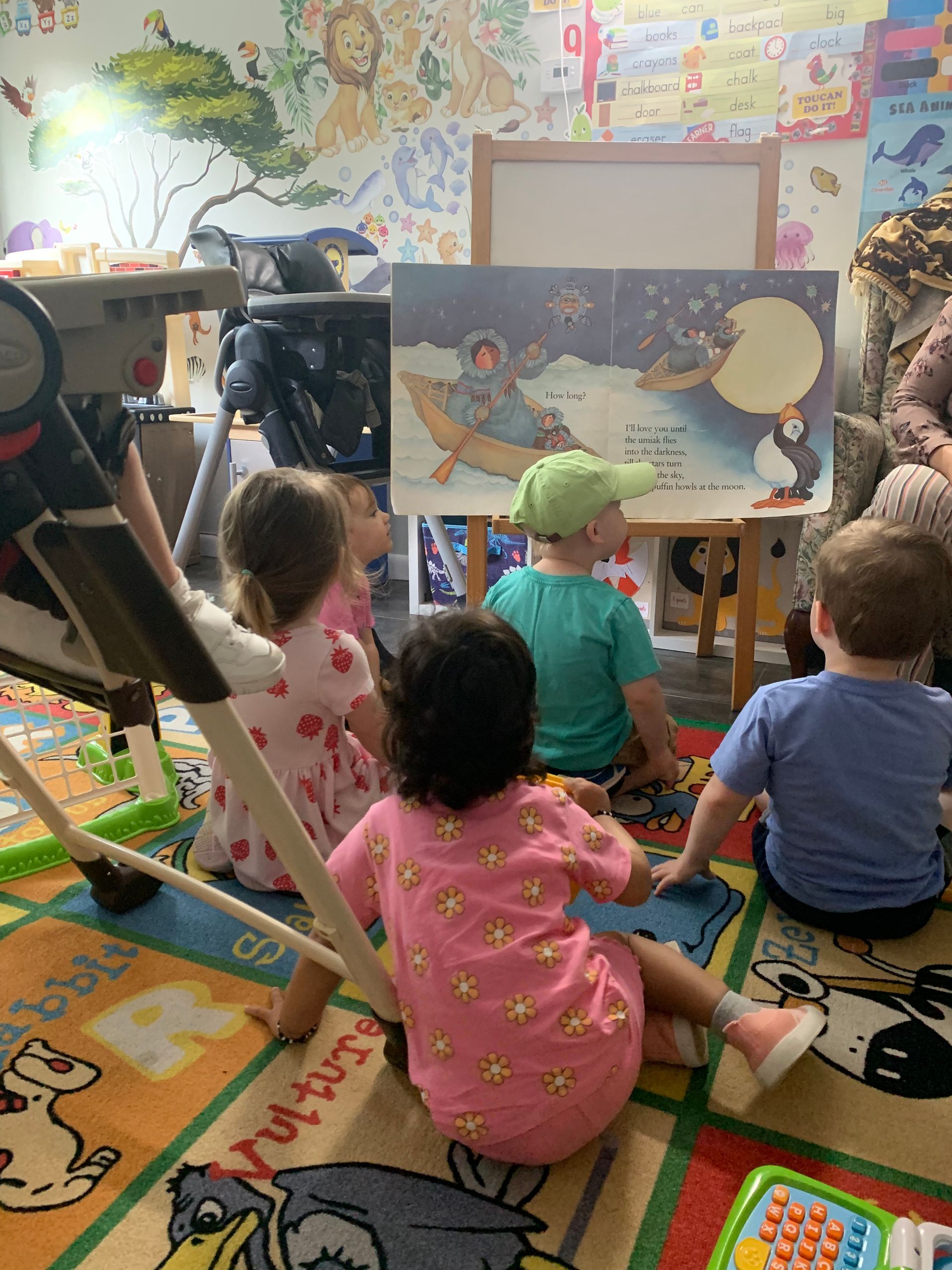 A group of children are sitting on the floor reading a book.