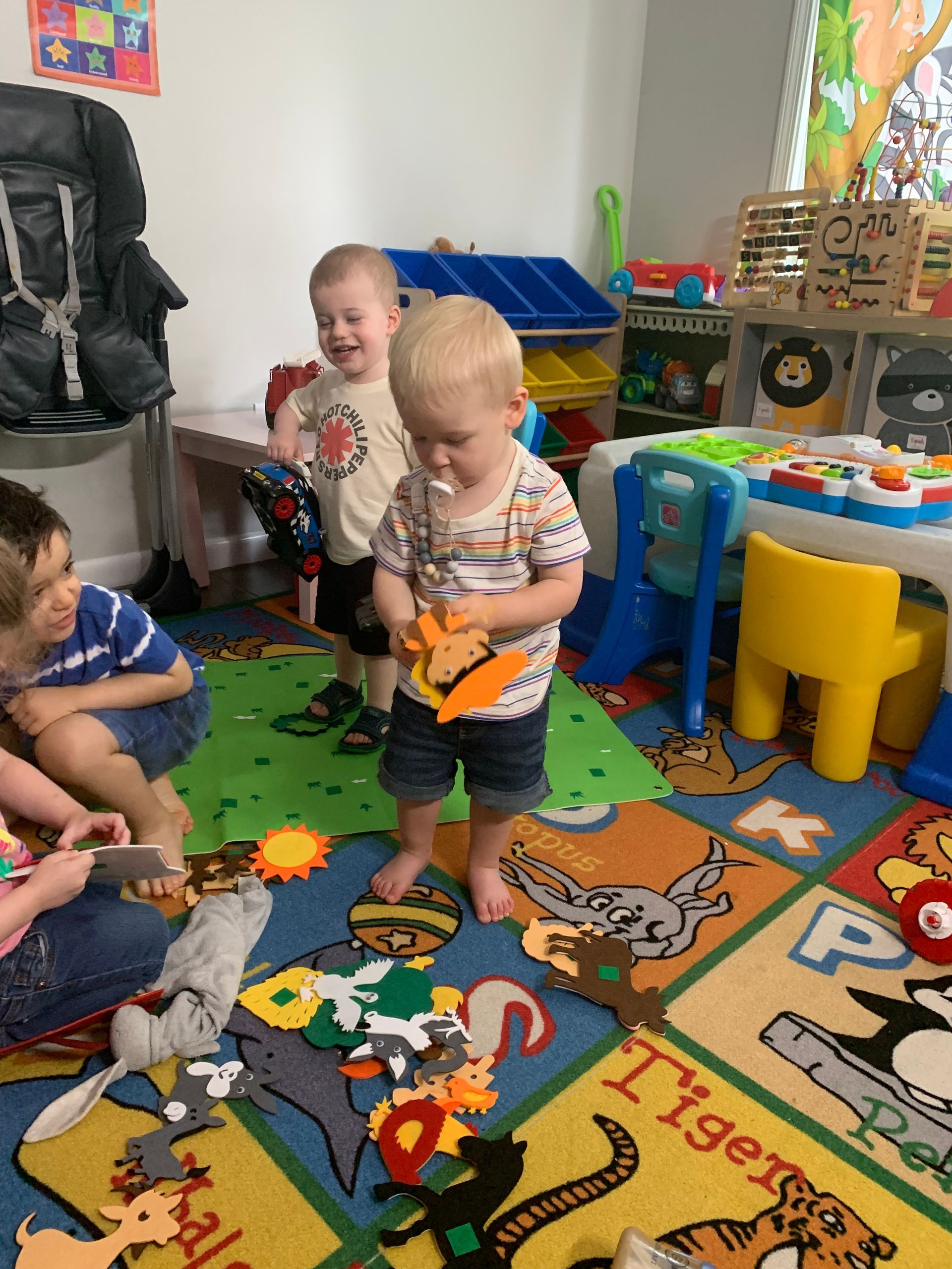 A group of children are playing with toys in a play room.
