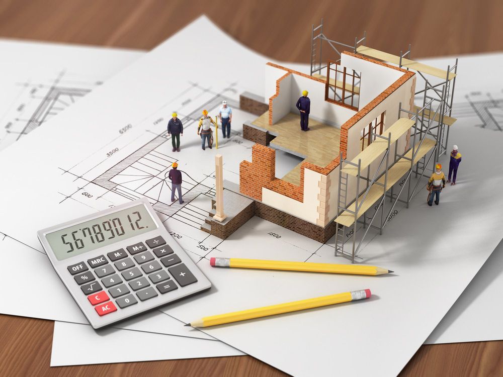 A Calculator, Pencils, and a Model of a House Are on a Wooden Table — A. Webber Building in Currarong, NSW