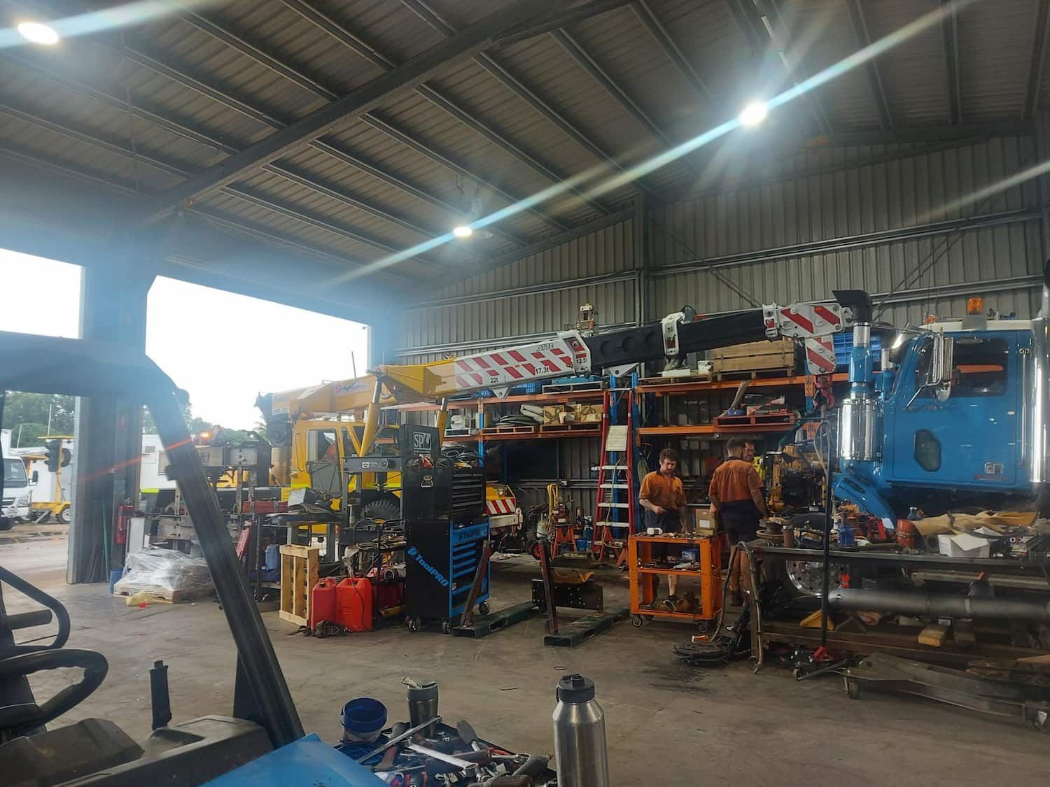 A Large Warehouse Filled With Lots of Trucks and Machinery — Bowen Mechanical & Haulage in Bowen, QLD