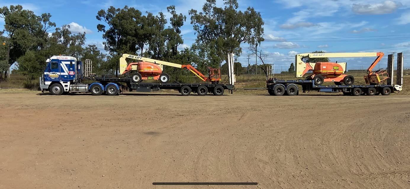 Two Trucks Are Parked Next to Each Other in a Dirt Field — Bowen Mechanical & Haulage in Bowen, QLD