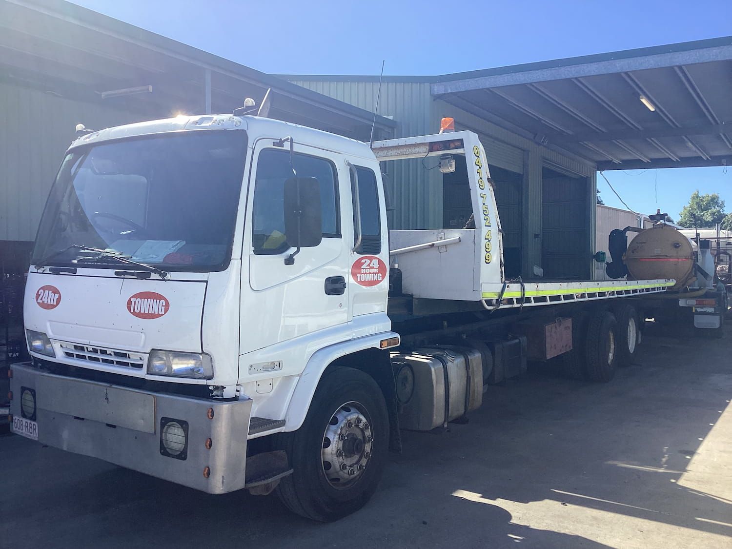 A White Tow Truck is Parked in Front of a Building — Bowen Mechanical & Haulage in Bowen, QLD