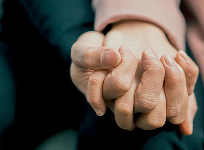 peer supporter and advocate holding hand of survivor