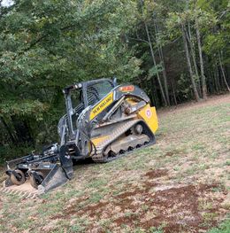 A bulldozer is going down a hill in the woods.