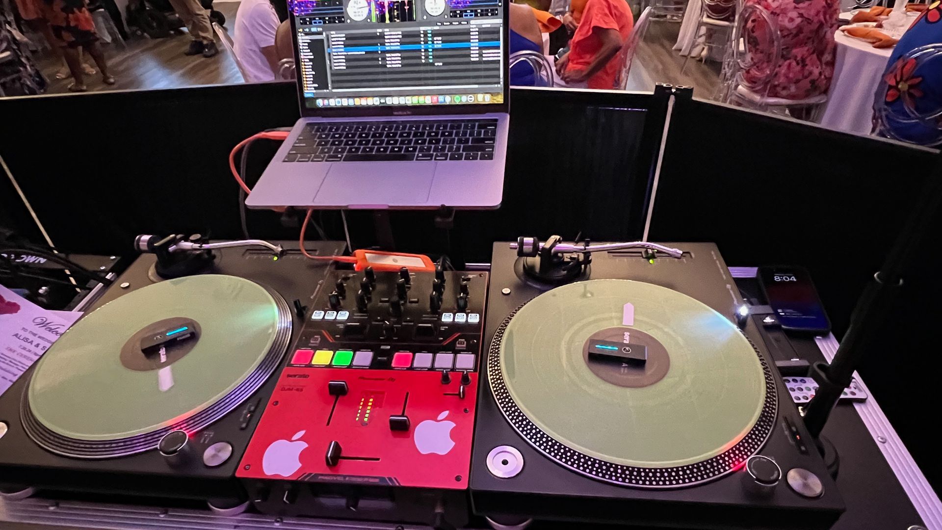 A dj set with two turntables and a laptop on a table.