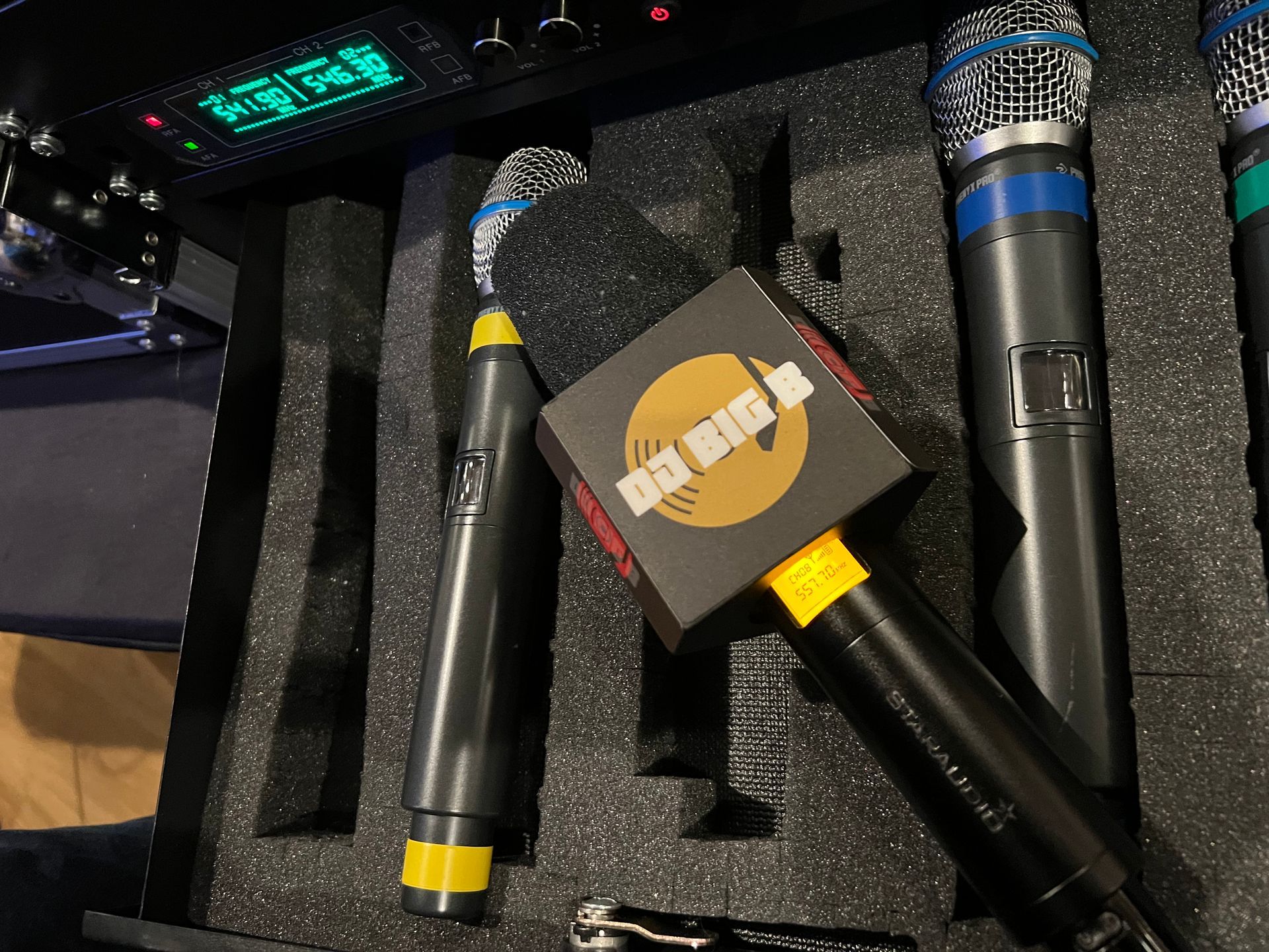 Several microphones are sitting in a case with a box that says ok hip hop