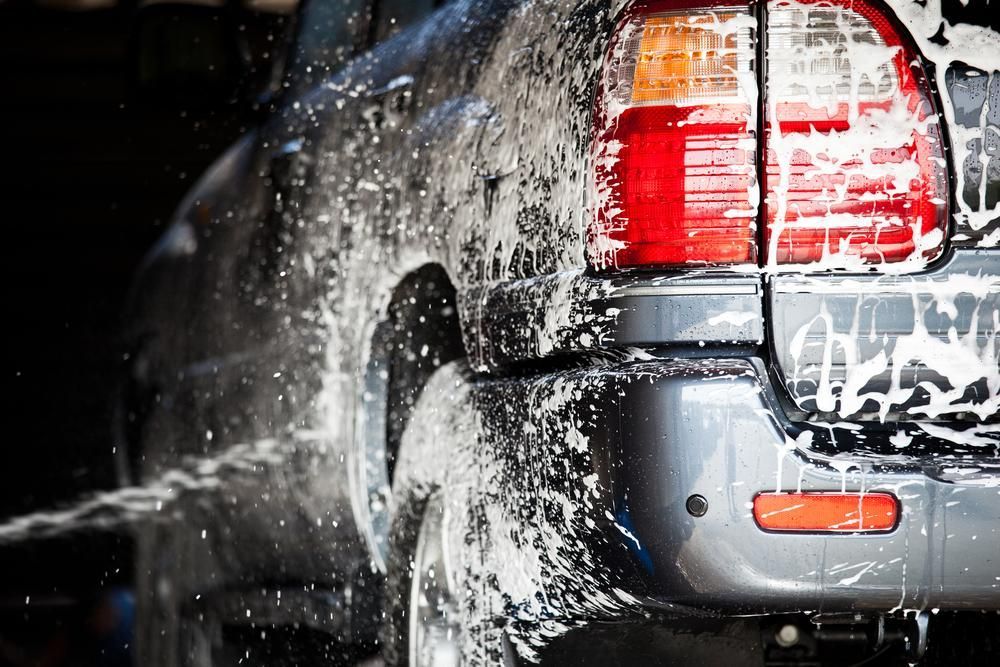 A Car is Being Washed With Soap and Water — Envirokleen Solutions In Slade Point, QLD
