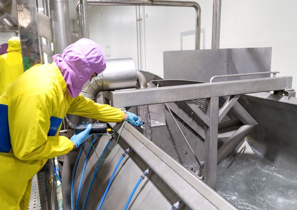 A Man in a Yellow Suit is Working on a Machine in a Factory — Envirokleen Solutions In Slade Point, QLD