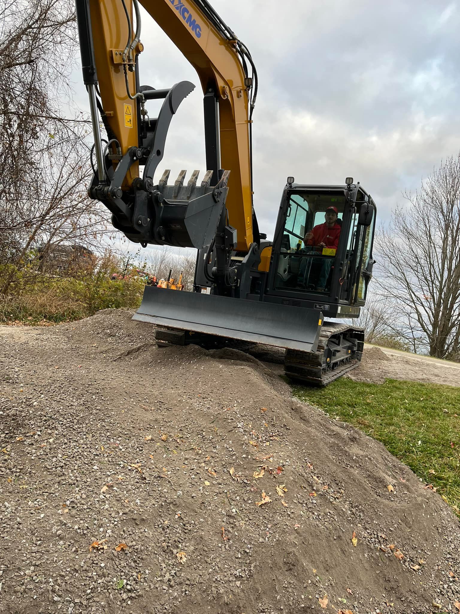 A man is driving a bulldozer on a gravel road.