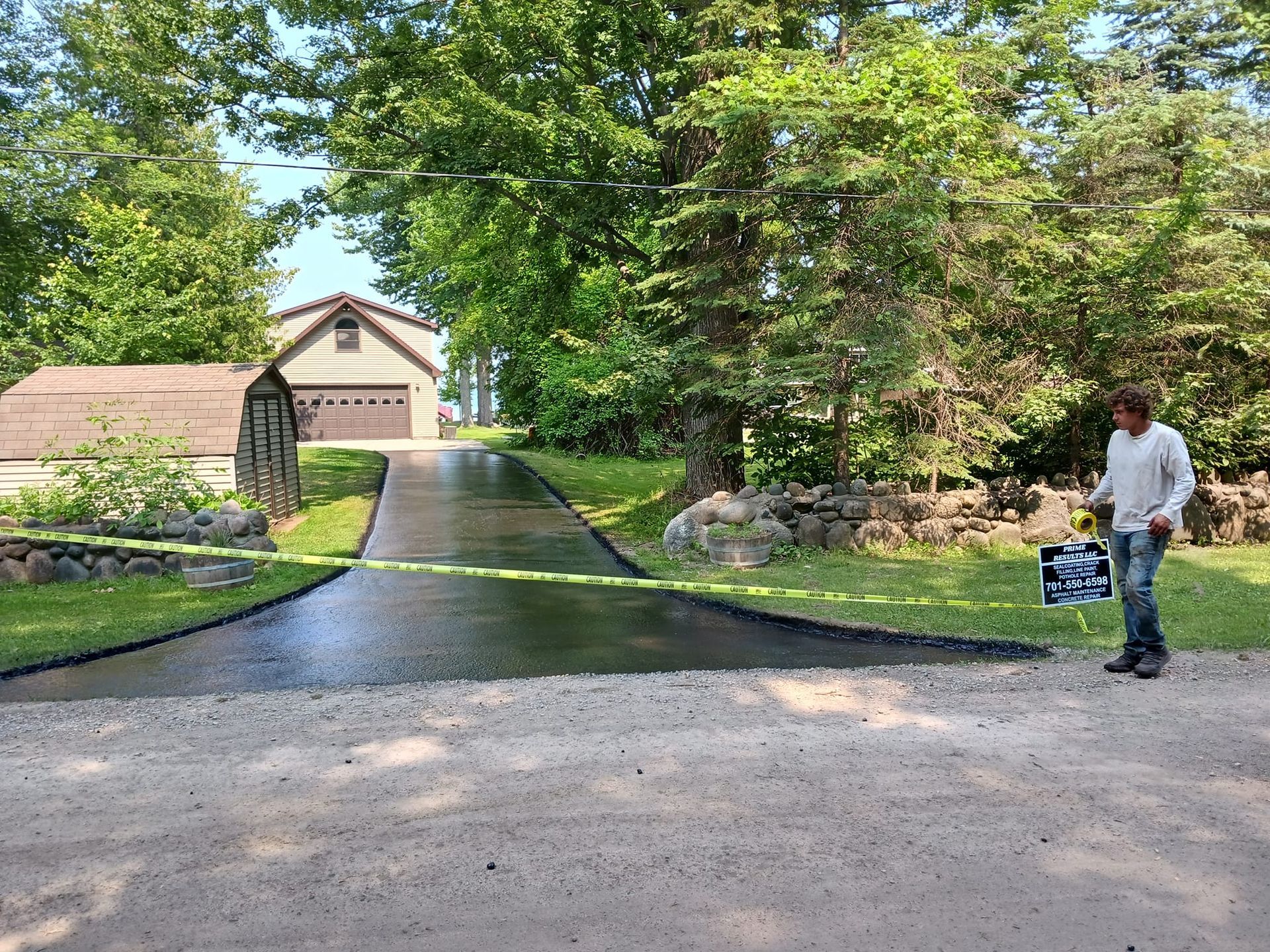 A man is walking down a driveway next to a garage.