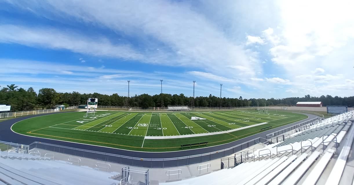 An aerial view of a football field with a blue sky in the background.