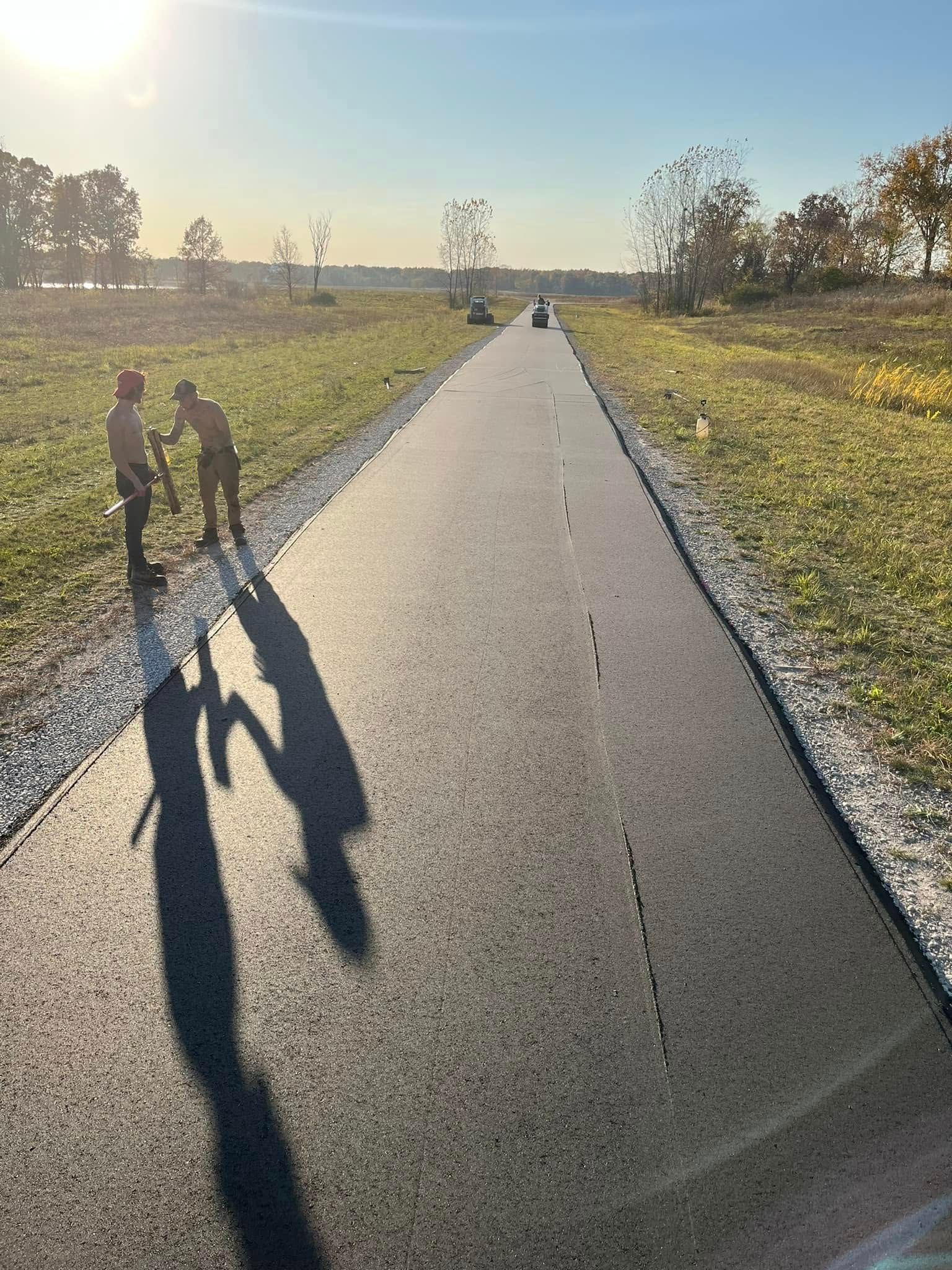 A couple of people standing on the side of a road.