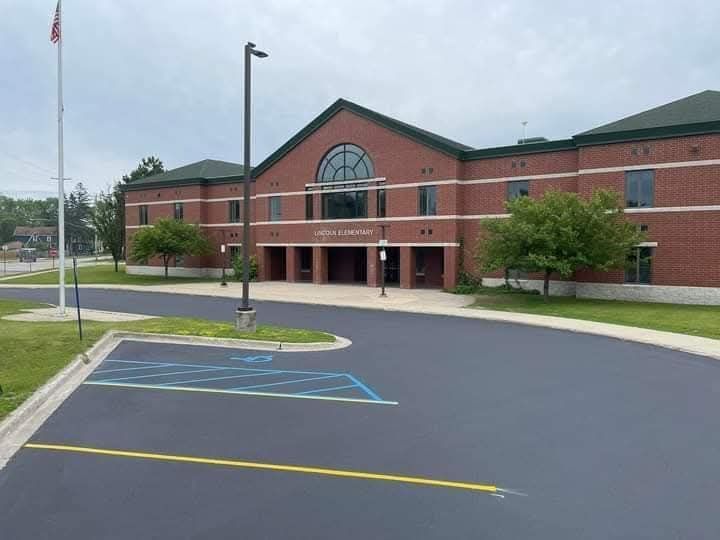 A large brick building with a handicapped parking spot in front of it.