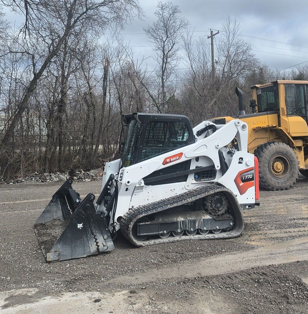 A dump truck is pulling a trailer with an excavator on it.