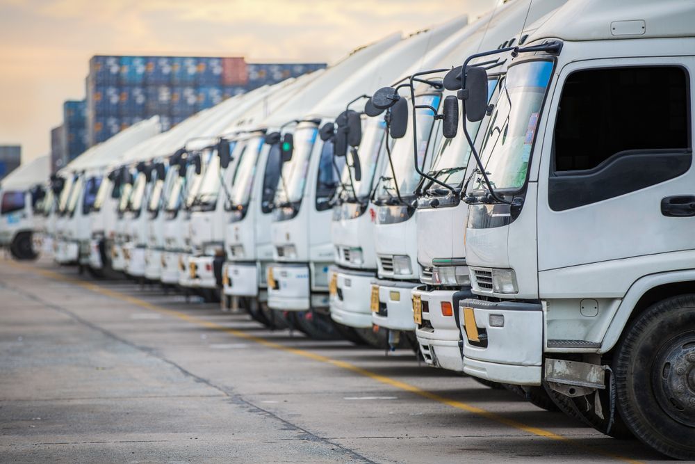 Row of White Semi-trucks Parked in a Lot — PBC Compliancing in Mackay, QLD
