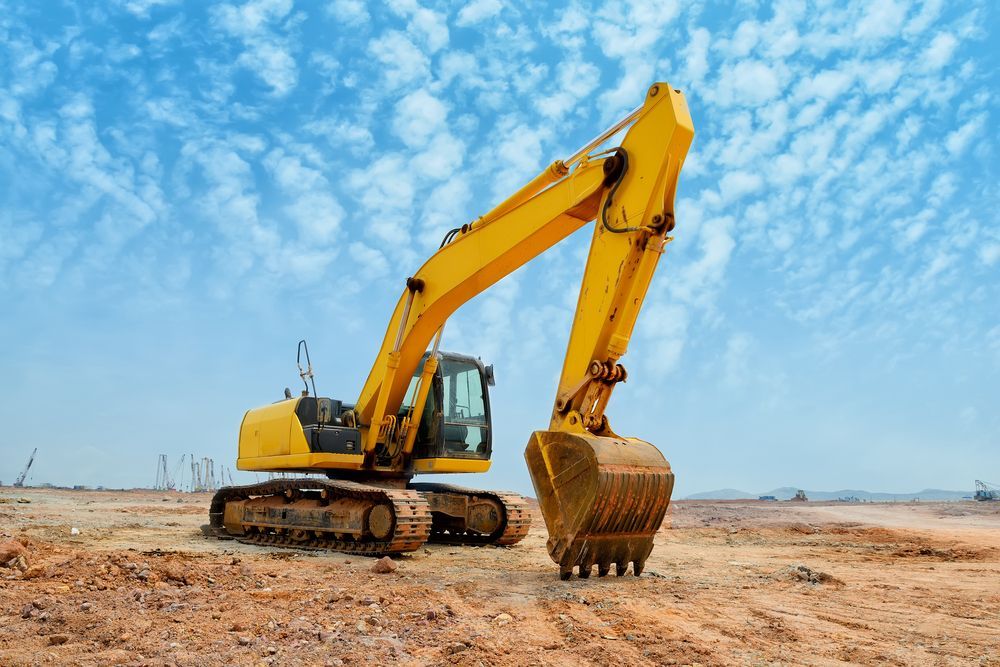 A Yellow Excavator Is Sitting on Top of A Dirt Field — PBC Compliancing Pty Ltd in Mackay, QLD